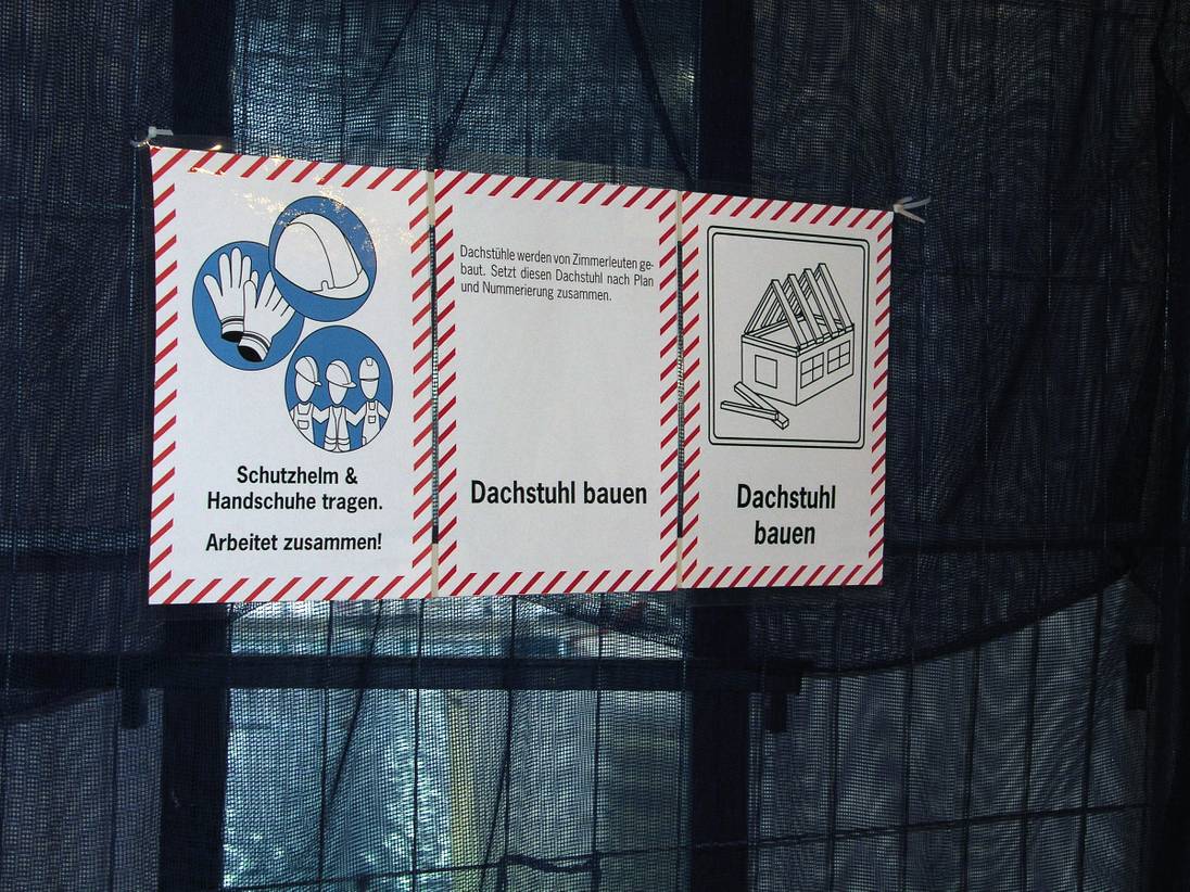 Foto eines schwarzen Netzes mit drei Schildern darauf.